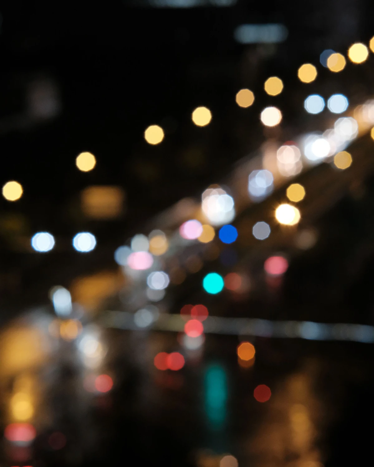 Out-of-focus city lights at night rendered as soft overlapping circles across a dark background.