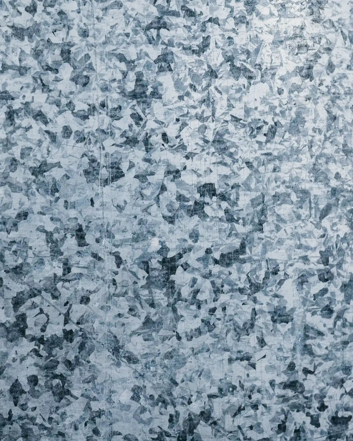 Close view of galvanized steel showing the mottled crystalline spangle of its zinc coating.