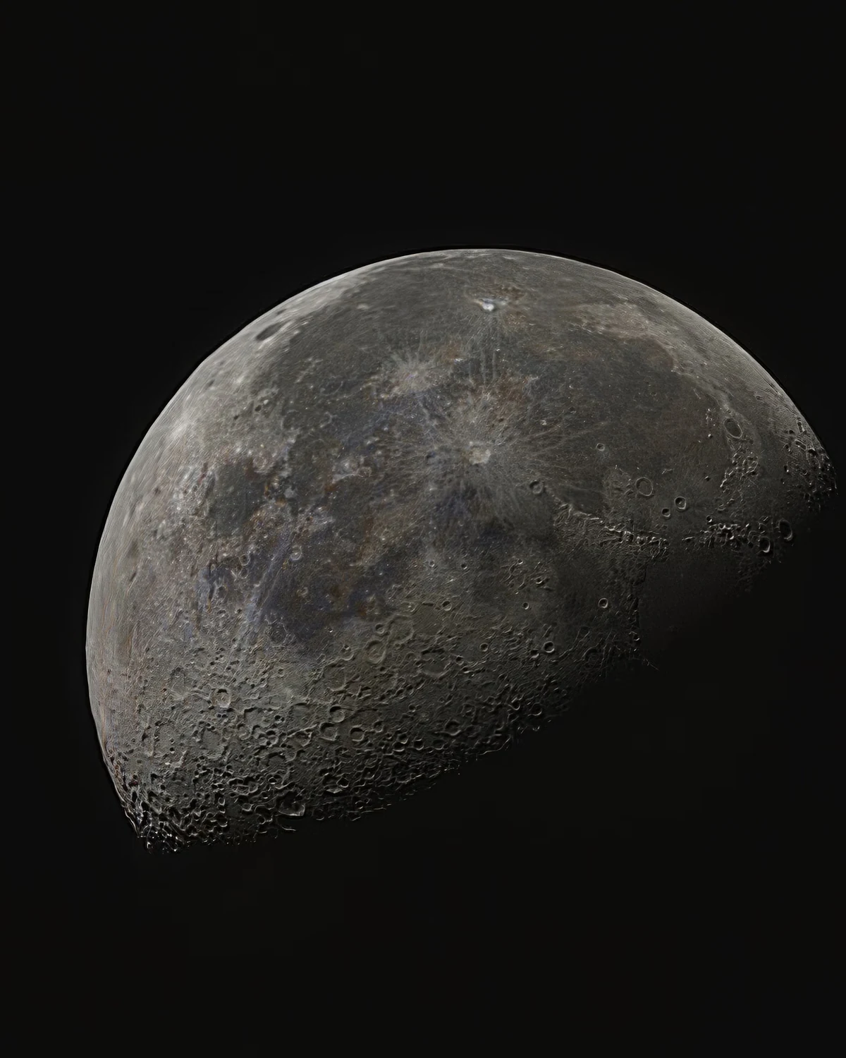 Telephoto view of a gibbous Moon, craters and dark maria sharp along the day-night line.